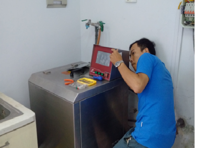 Kỹ sư đang kiểm tra và sửa chữa máy đo độ bền màu sau giặt của Atlas , tại công ty Thygesen.